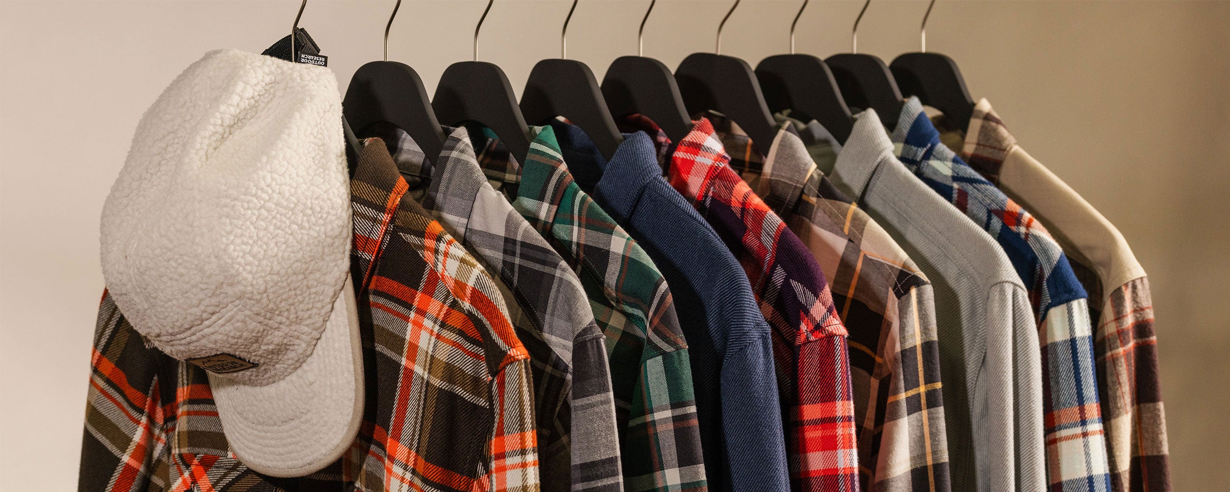 Close up of a variety of Outdoor Research flannel shirts hanging on a rack.