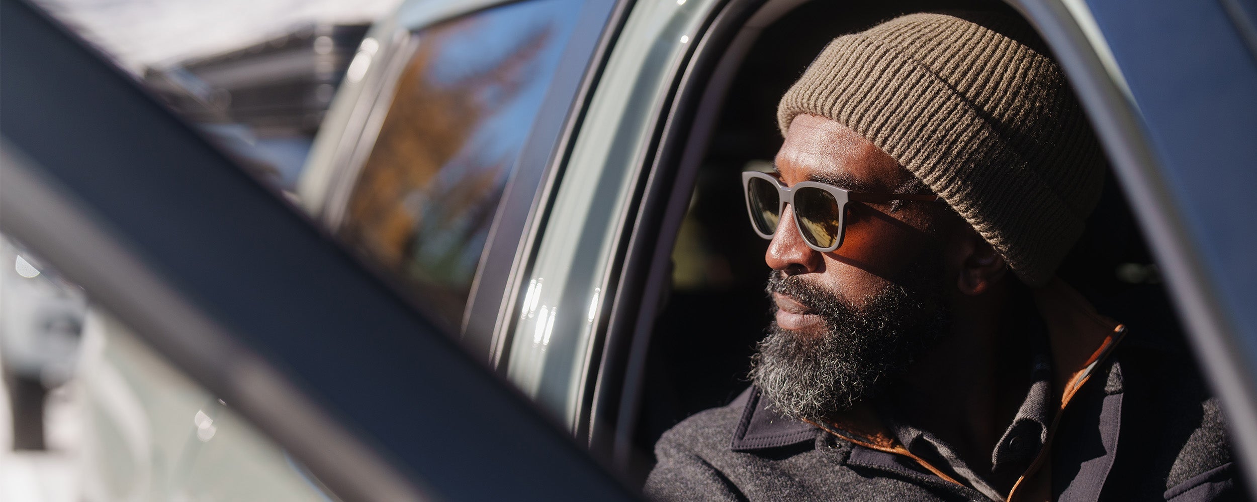 Male sitting in his car looking out wearing Outdoor Research Men's Ranger Shirt Jacket Black and Tokul Beanie.
