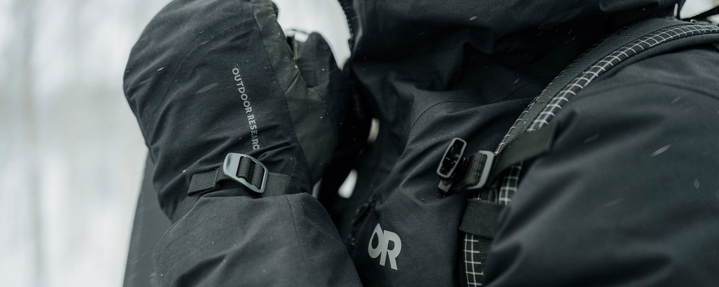 Athlete Max Djenohan climbs a mountain while gripping a Pickaxe with the Outdoor Research Team Gore-Tex 3-Finger Gloves in Black. 