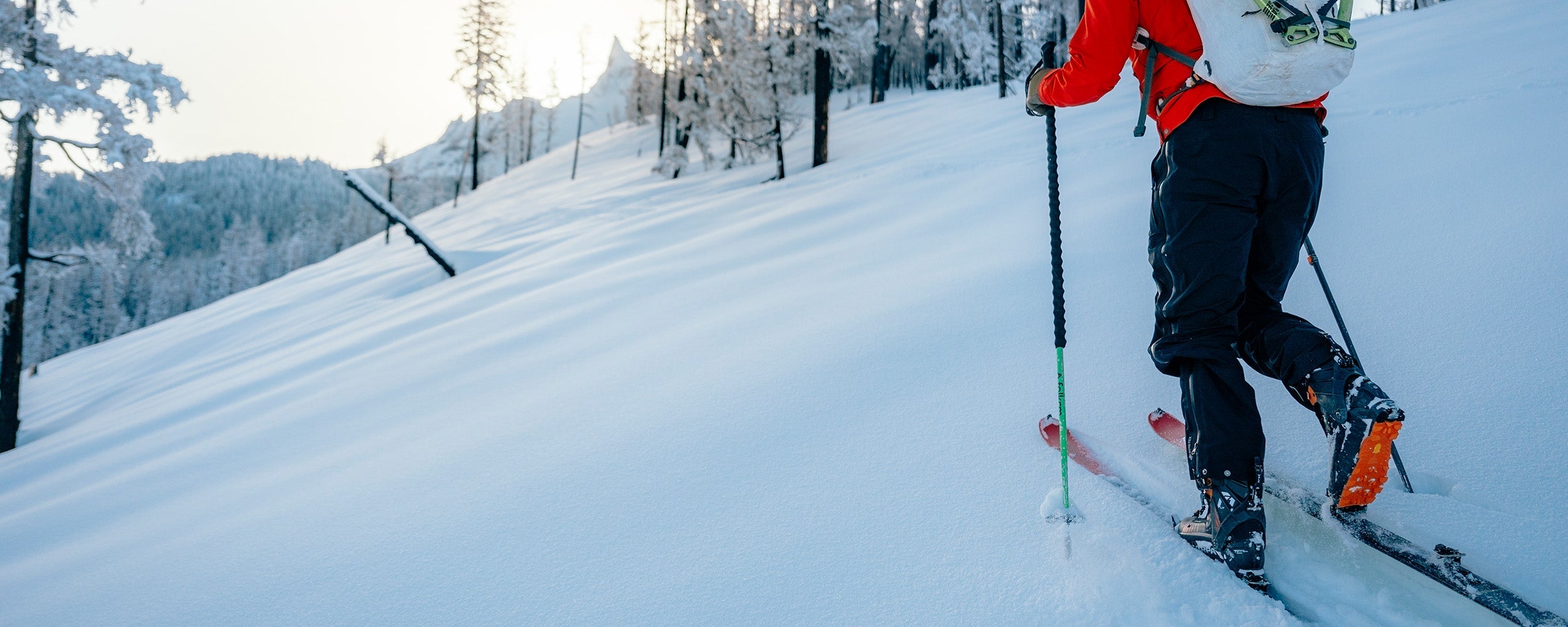 Male mountaineering in the snow wearing Outdoor Research Men's Headwall Gore-Tex 3L Jacket Lingonberry. 