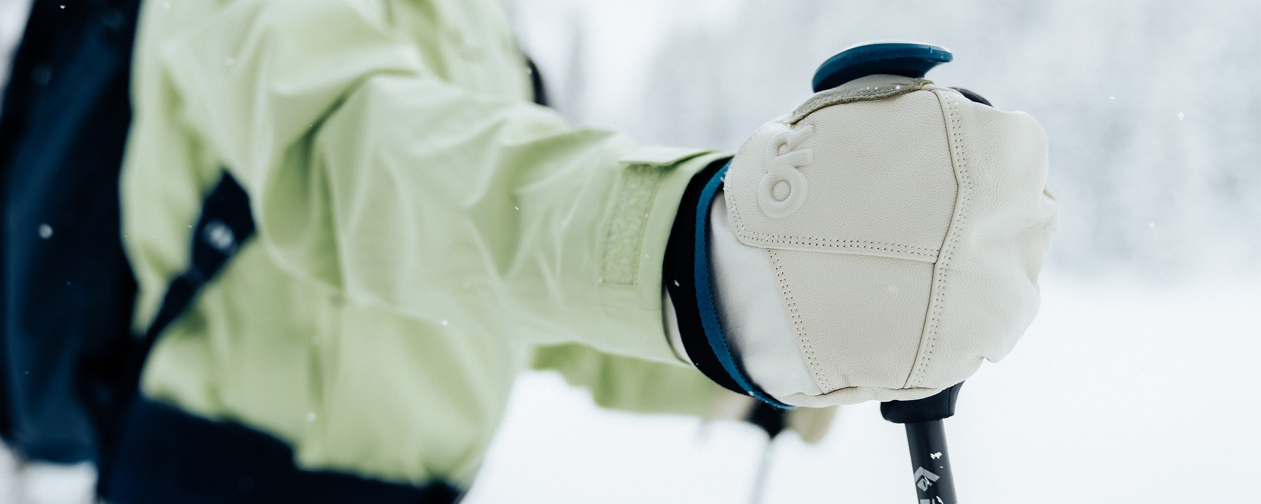 A woman wears the Team Gore-Tex Mitts in Oyster while out on a ski tour.