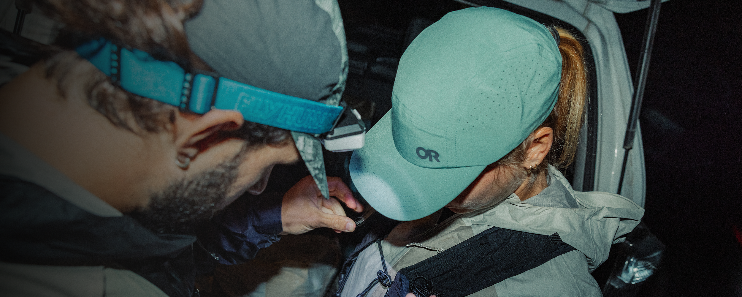 Two people getting geared up for their adventure wearing Outdoor Research Swift Lite Tech Caps Malachite. 
