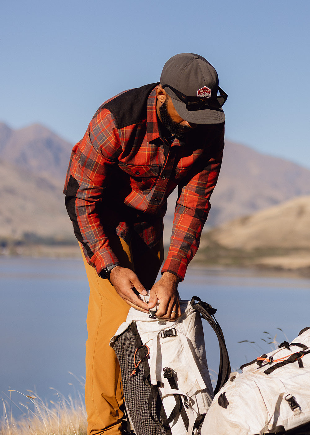 A man wears the Wallingford Flannel Shirt Jacket in Jupiter Plaid while out on a hike.