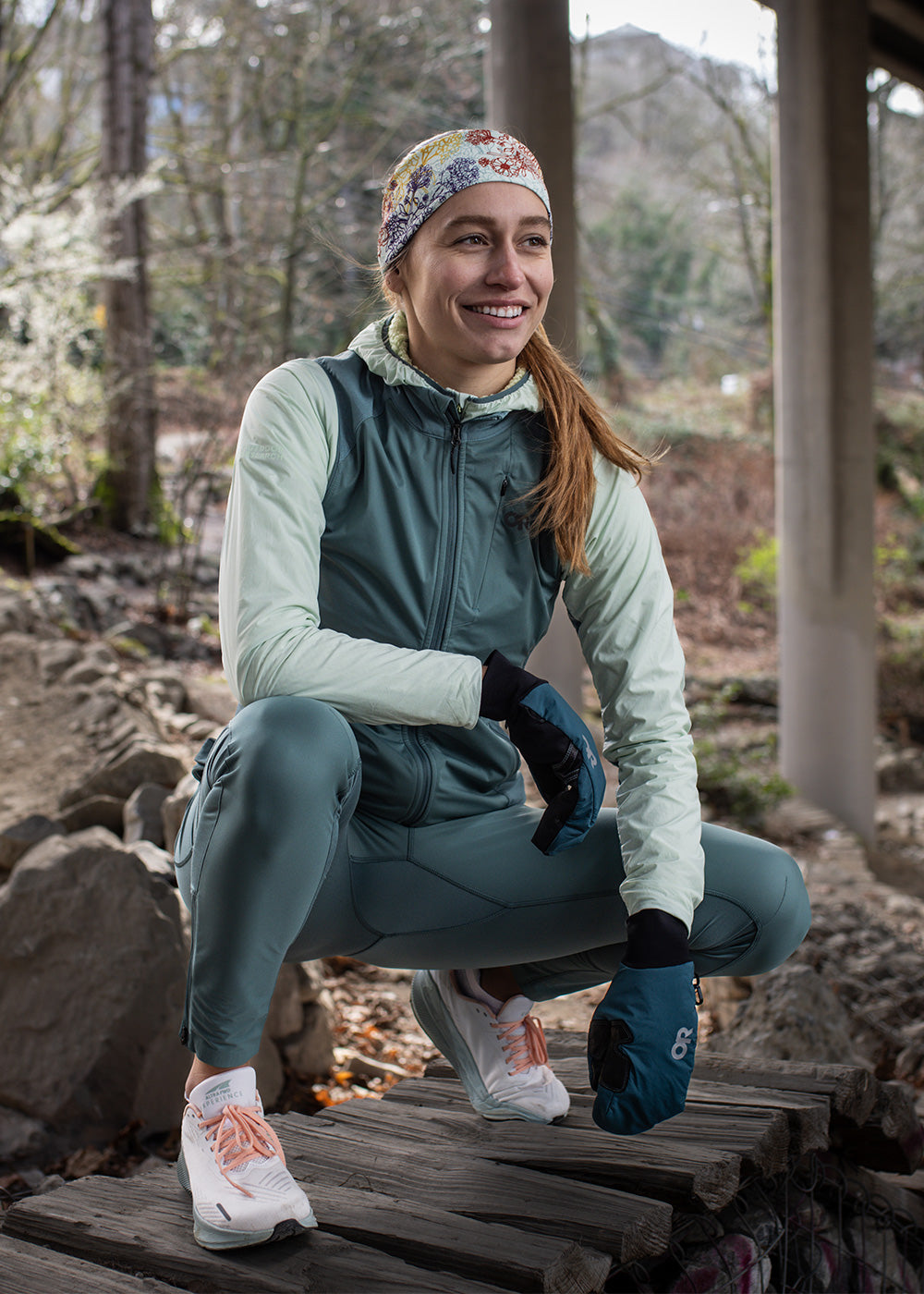 A woman runs along a path while wearing the Outdoor Research Deviator Wind Leggings.