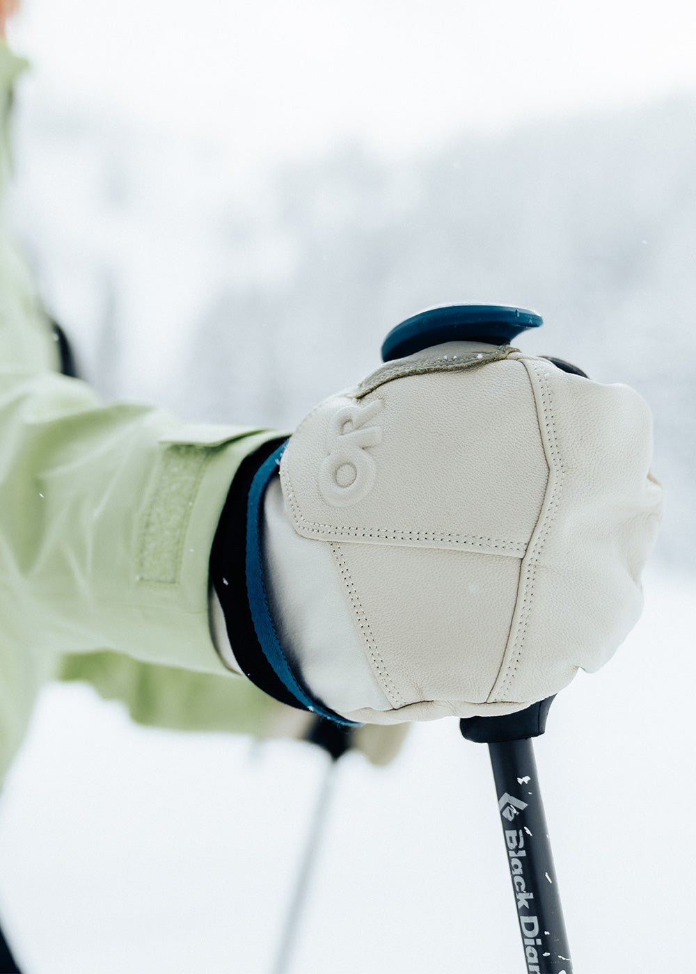 A woman wears the Team Gore-Tex Mitts in Oyster while out on a ski tour.