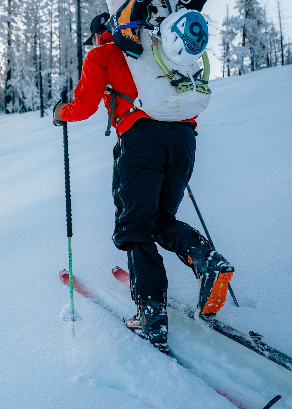 Male mountaineering in the snow wearing Outdoor Research Men's Headwall Gore-Tex 3L Jacket Lingonberry. 