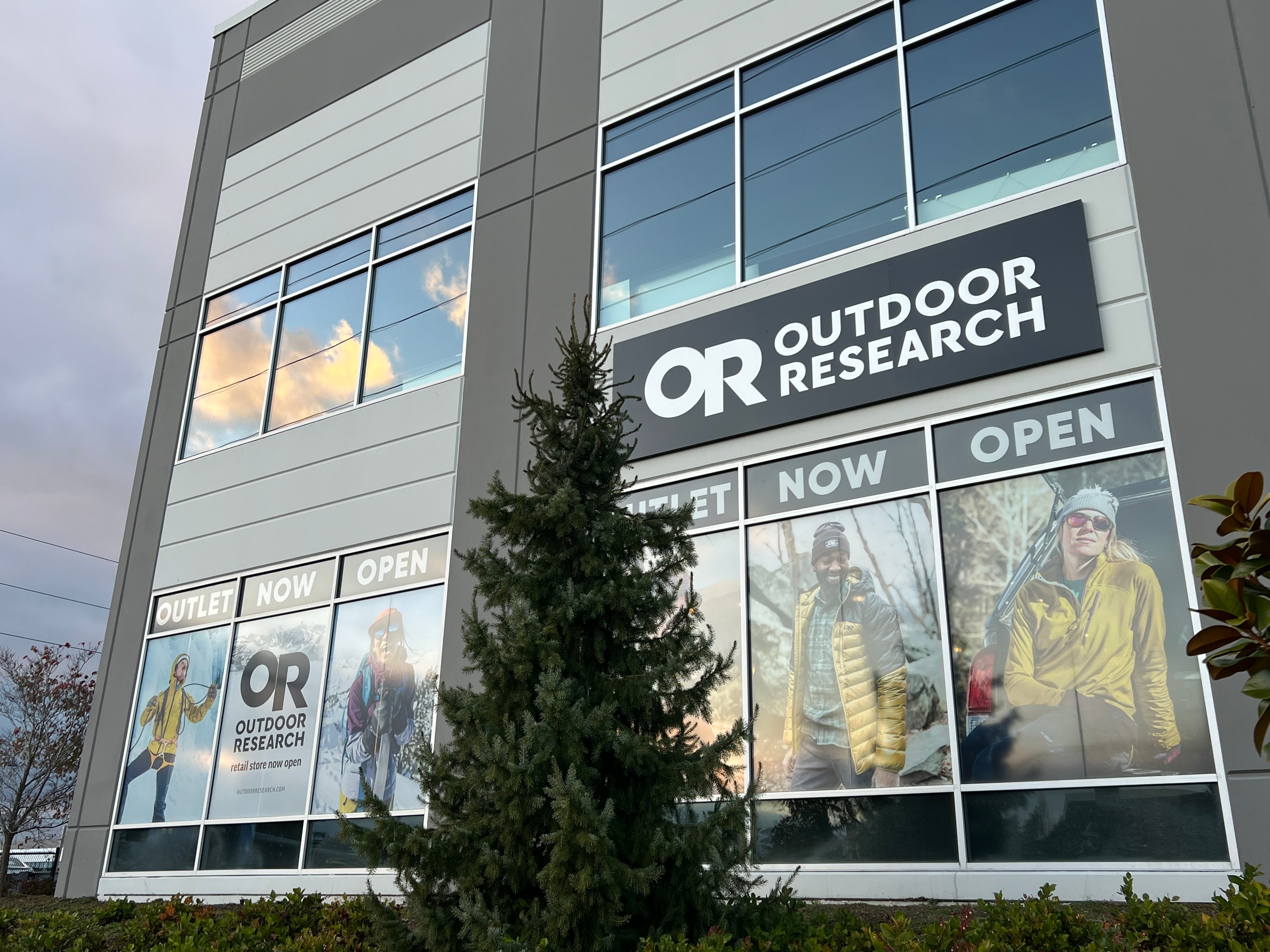 Exterior view of the a building with large glass windows with pictures of models wearing Outdoor Research sportswear.