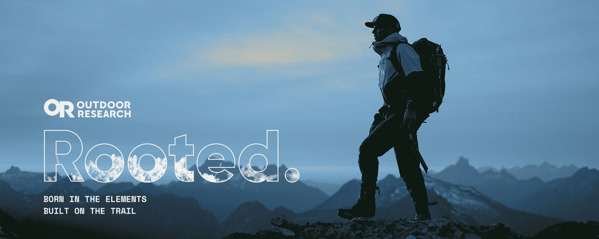 Graphic of a man standing atop a mountain, with the Outdoor Research logo and the words Rooted. with "born in the elements built on the trail" underneath.