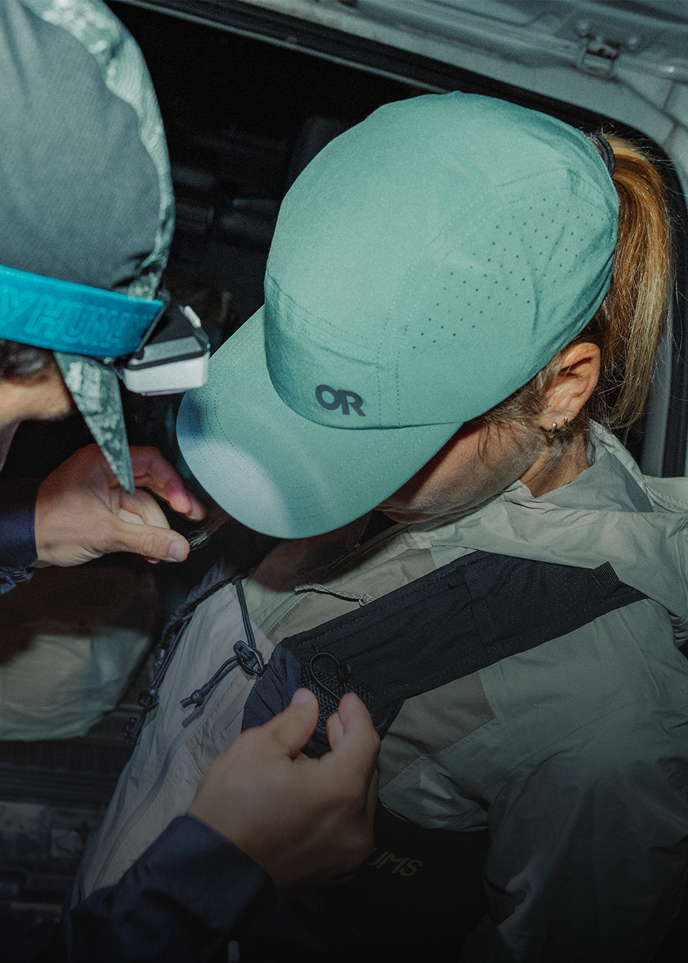 Two people getting geared up for their adventure wearing Outdoor Research Swift Lite Tech Caps Malachite. 