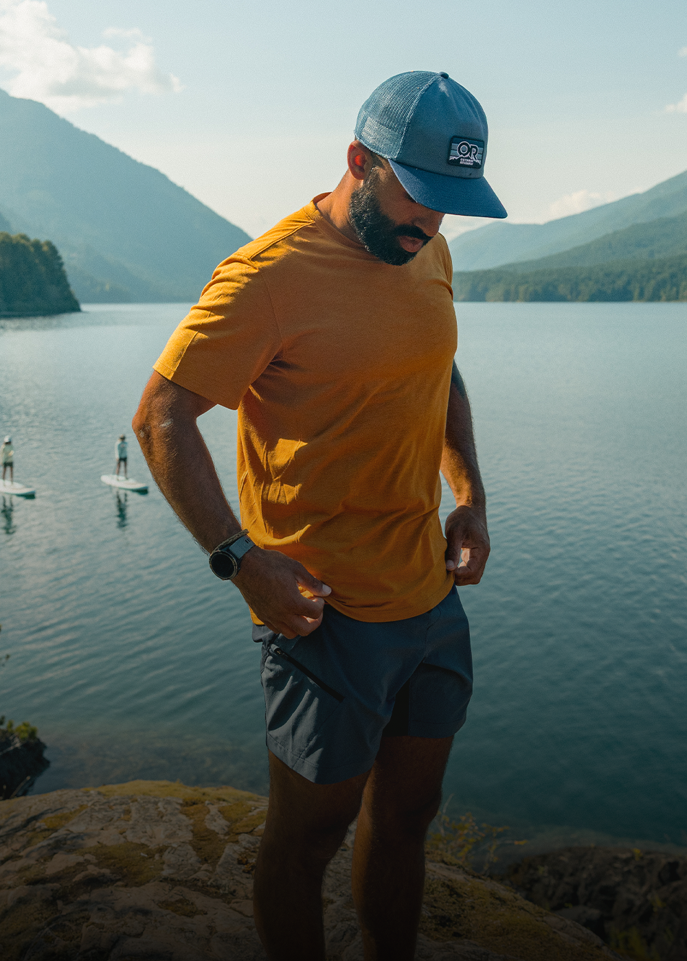 Three friends wearing Outdoor Research Sportswear rest on the side of a Float Plane beneath the sun.